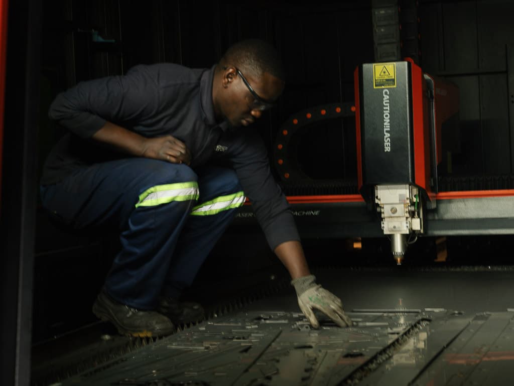 Operator removing laser-cut parts from the nest