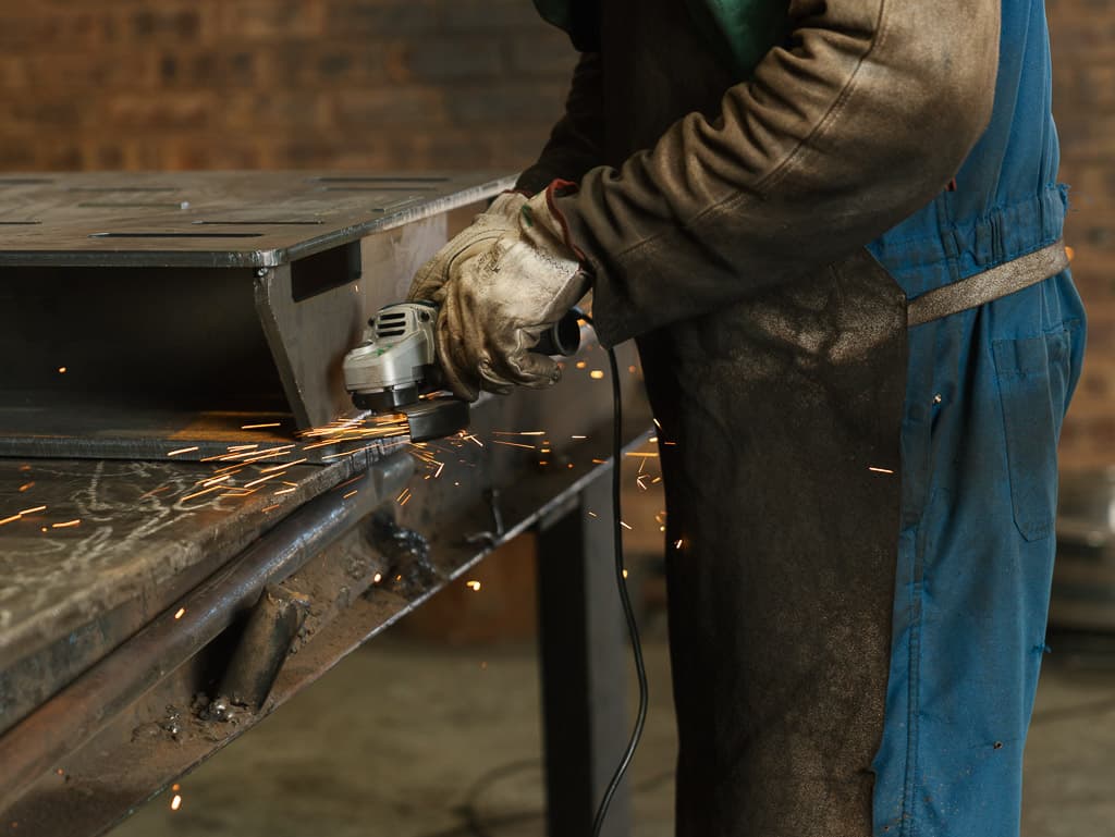 Grinding and finishing a fabricated sheet metal enclosure with sparks