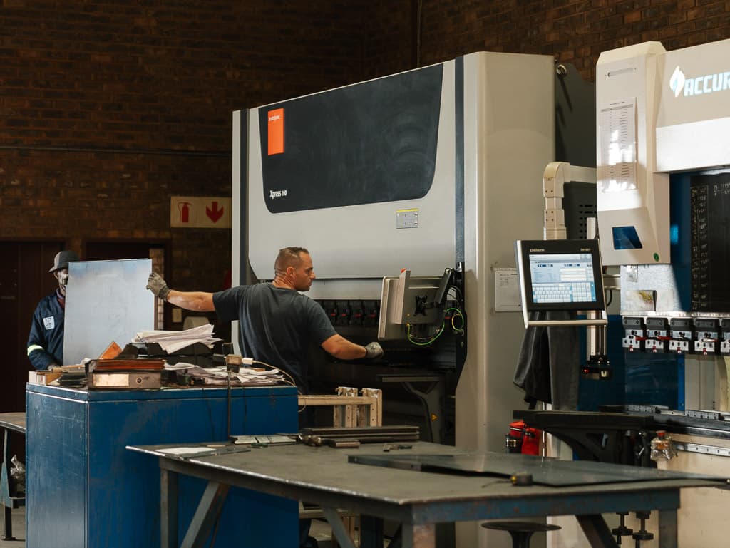 Operator at the CNC press brake control panel