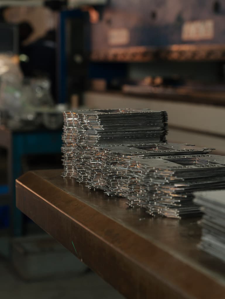 Laser-cut components stacked on the workshop bench